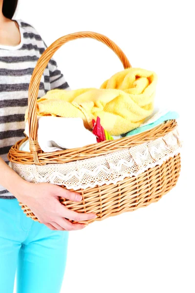 Frau hält Wäschekorb mit sauberer Kleidung, Handtüchern und Stecknadeln, isoliert auf weiß — Stockfoto