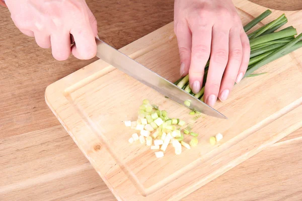 Female hand cutting chives on cutting board — Stock Photo, Image