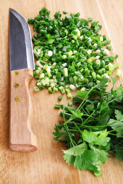 Cebolla verde picada con cuchillo en tabla de cortar — Foto de Stock