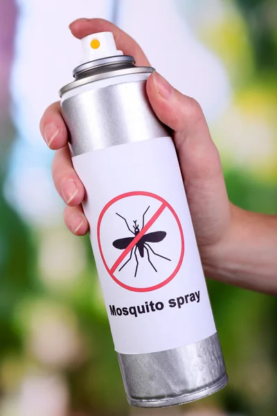 Рука держит комаров спрей на фоне природы — стоковое фото