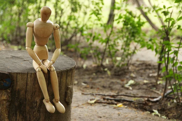 Marionnette pose en bois assise sur du bois, à l'extérieur — Photo