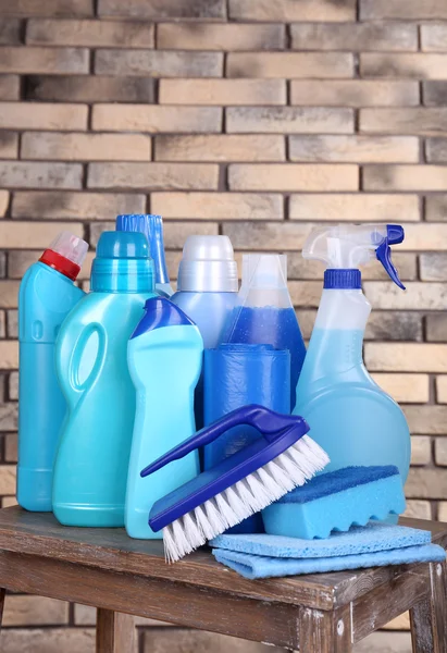 Cleaning products on shelf on bricks wall background