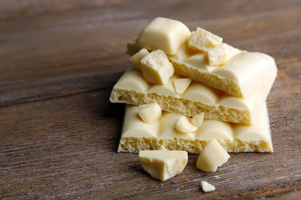 Barra di cioccolato bianco rotto su sfondo di legno colore — Foto Stock