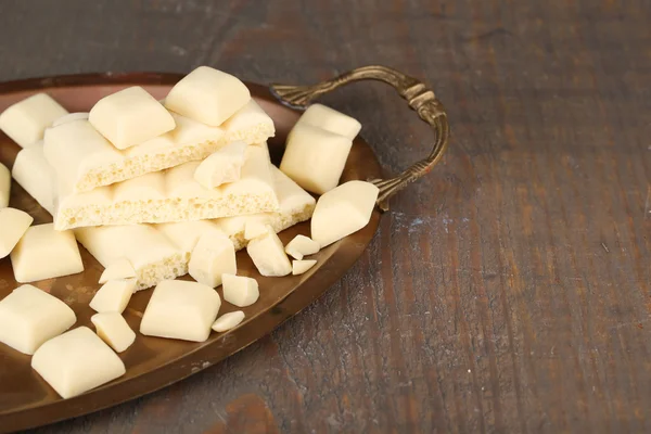 Witte chocolade bar gebroken op het dienblad, op een houten achtergrond kleur — Stockfoto