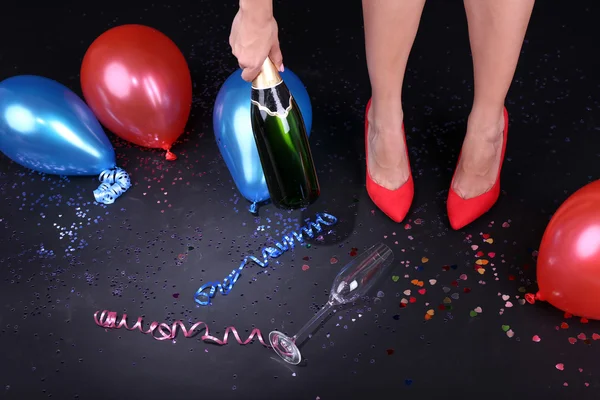 Gambe con confetti, champagne e palloncini sul pavimento — Foto Stock