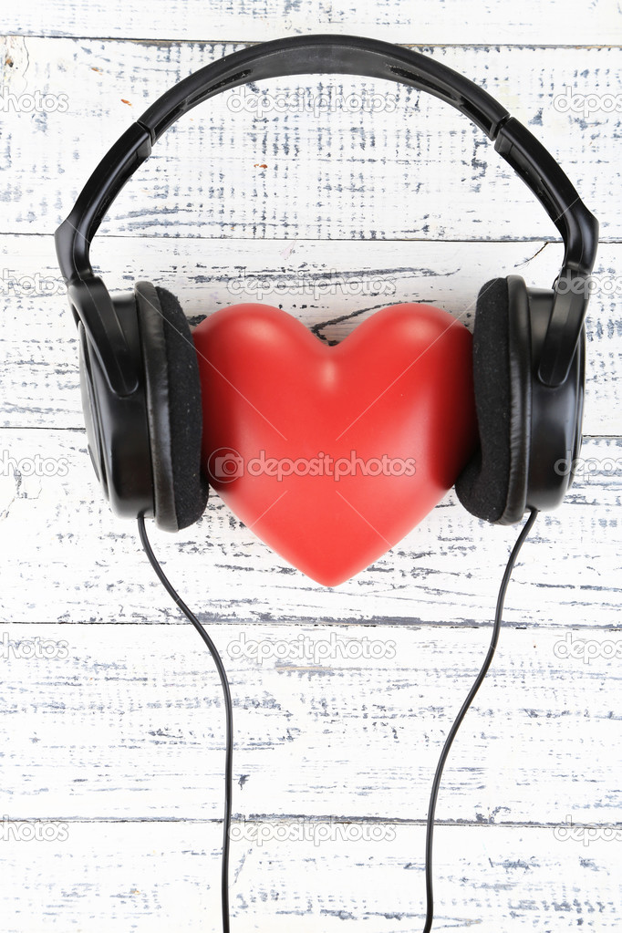 Headphones and heart on wooden background