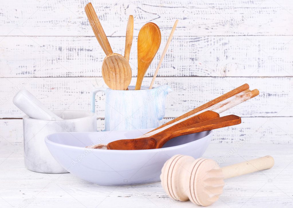 Composition of wooden cutlery, mortar, bowl on wooden background