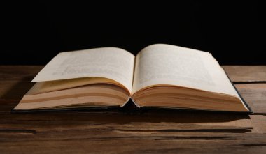 siyah arka plan üzerine masada eski kitap