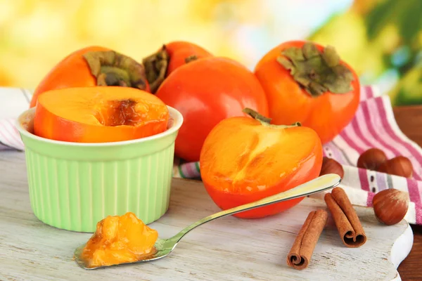 Rijp kaki met kaneel op tafel op lichte achtergrond — Stockfoto