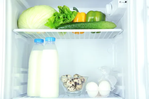 Botellas de leche, verduras y frutas en nevera abierta. concepto de dieta de pérdida de peso . — Foto de Stock