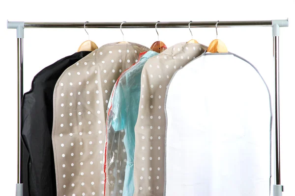 Clothes in cases for storing on hangers, on gray background — Stock Photo, Image