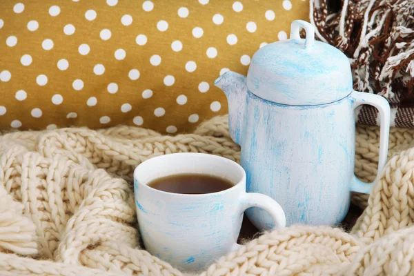 Cup och tekanna med halsduk på sängen på nära håll — Stockfoto