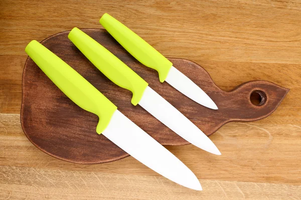 Кухонные ножи и разделочная доска на деревянном столе — стоковое фото