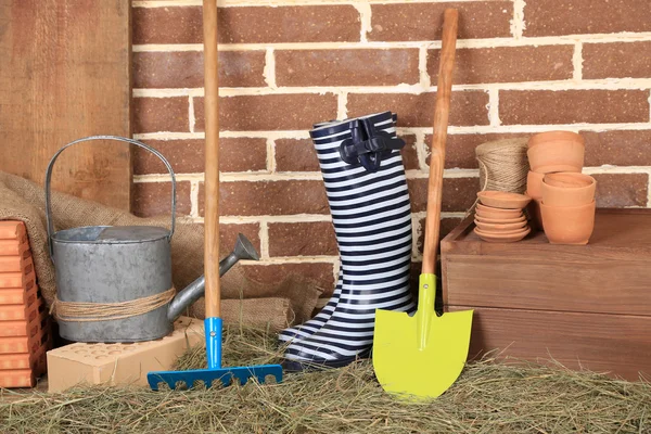 Herramientas de jardinero sobre fondo de ladrillos — Foto de Stock