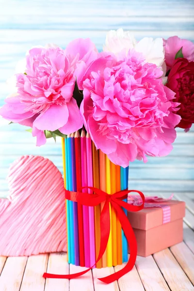 Ahşap arka plan üzerinde renkli kalemler vazoda güzel çiçekler — Stok fotoğraf
