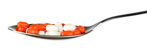 Bunte Pillen auf Löffel auf weißem Hintergrund Nahaufnahme — Stockfoto