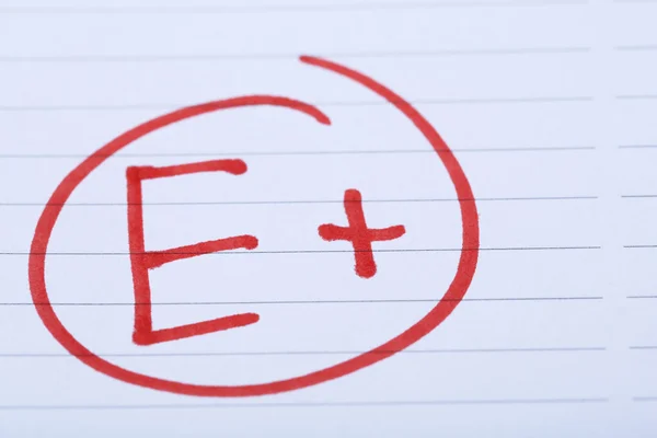 Grade E plus written on an exam paper — Stock Photo, Image