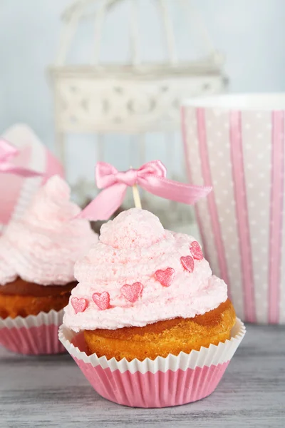 Tasty cup cakes with cream on grey wooden table — Stock Photo, Image