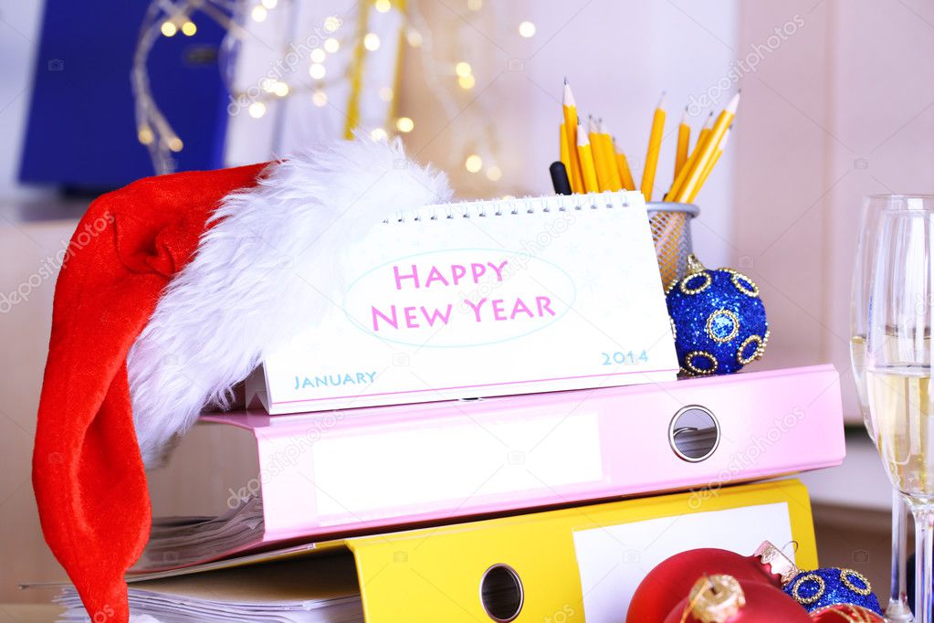 Table with office supplies, calendar and Christmas tinsel close-up