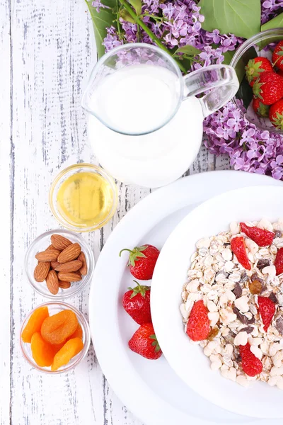 Gezonde ontbijtgranen met melk en fruit op houten tafel — Stockfoto