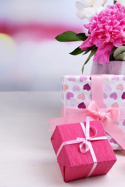 Composition of beautiful peonies in vase, tea in cup and marshmallow, on table, on light background — Stock Photo, Image