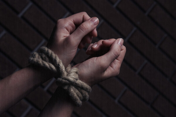 Tied hands on dark background