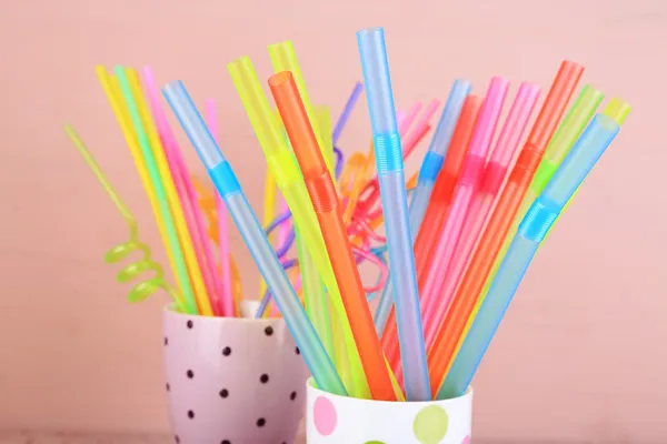 Straws in cups on pink background — Stock Photo, Image