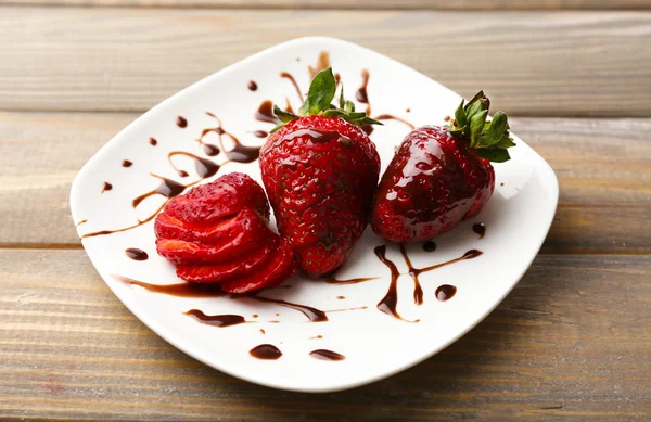 Fraises mûres rouges avec chocolat sur table en bois — Photo