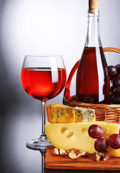 Pembe şarap, üzüm ve gri arka plan üzerine peynir — Stok fotoğraf