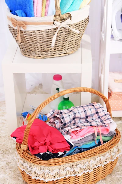 Serviettes et vêtements colorés dans des paniers, sur le fond intérieur — Photo