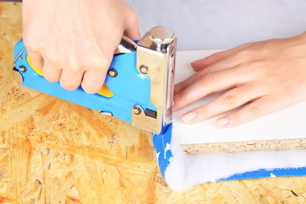 Крепление ткани и картона с помощью строительного степлера — стоковое фото