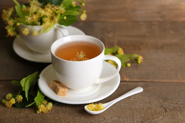 Tasty herbal tea with linden flowers on wooden table — Stock Photo, Image