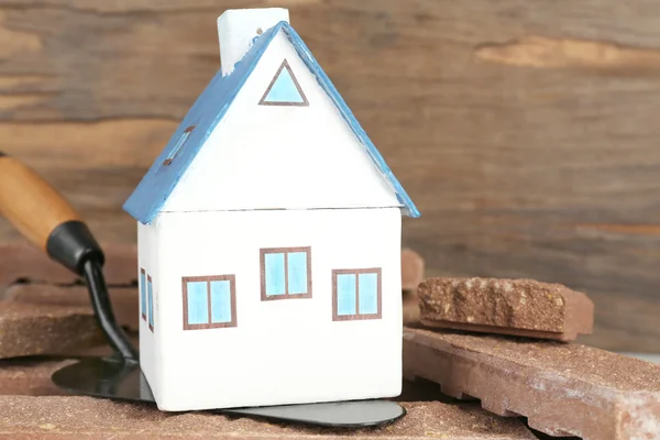 Trä leksak hus på murslev och plattor på trä bakgrund, närbild — Stockfoto