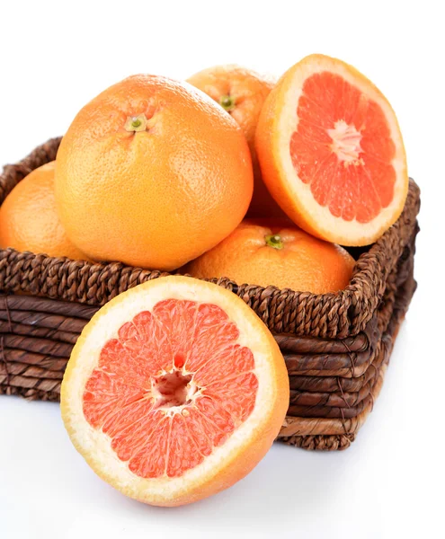 Rijp grapefruits in rieten mand geïsoleerd op wit — Stockfoto