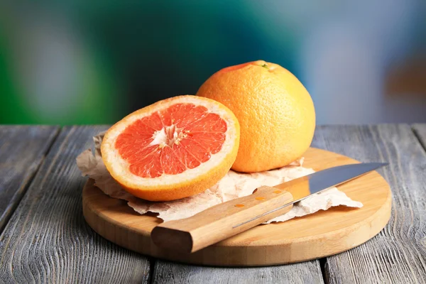 Pomelos maduros sobre tabla de madera, sobre fondo brillante — Foto de Stock