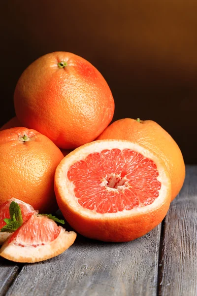 Rijp grapefruits op houten bord, op donkere kleur achtergrond — Stockfoto