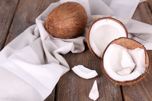 Trasiga kokos med servett på trä bakgrund — Stockfoto