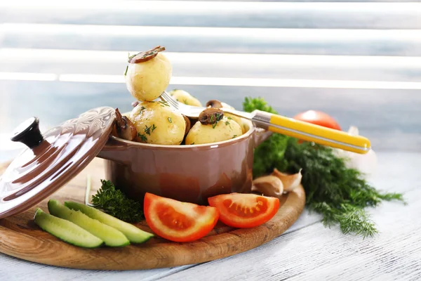 Las patatas jóvenes hervidas en la cacerola con verduras en la mesa de madera, de cerca —  Fotos de Stock