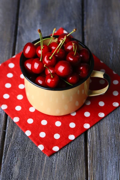 Cerezas dulces en taza sobre fondo de madera — Foto de Stock