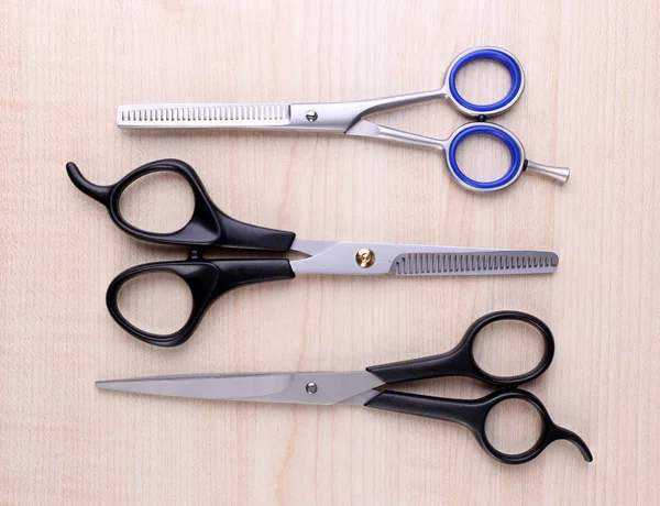 Profesjonalny salon fryzjerski narzędzia nożyczki na jasnym tle drewniane — Zdjęcie stockowe