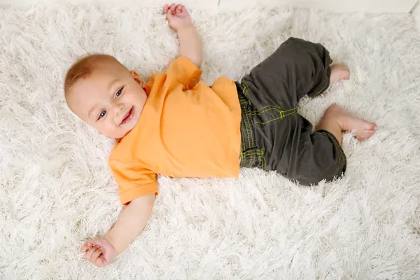 Bayi laki-laki lucu tergeletak di lantai di kamar — Stok Foto