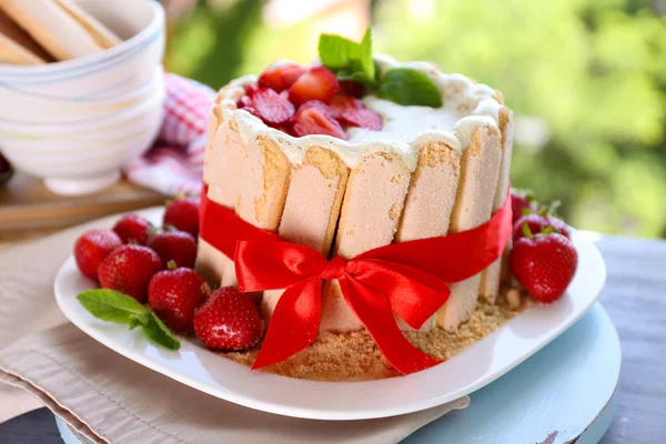 Gâteau savoureux Charlotte aux fraises fraîches sur fond vert nature — Photo