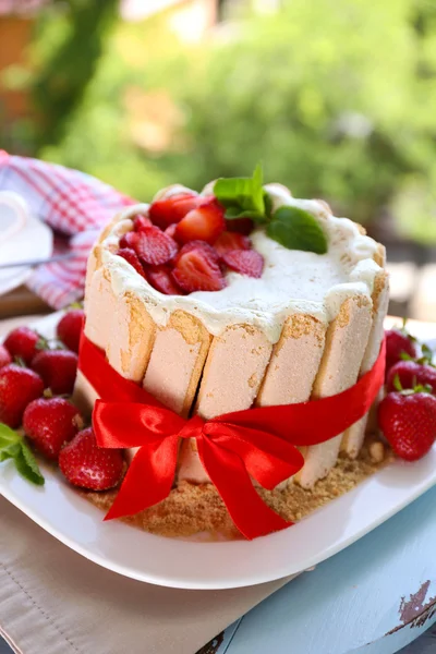 Leckere Torte Charlotte mit frischen Erdbeeren auf grünem Naturhintergrund — Stockfoto