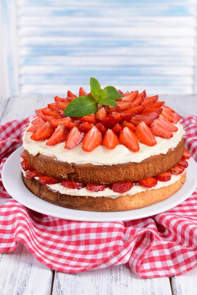 Délicieux gâteau aux biscuits avec des fraises sur la table sur fond clair — Photo