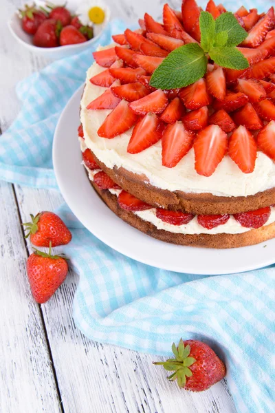 Delicious biscuit cake with strawberries on table close-up — Stock Photo, Image