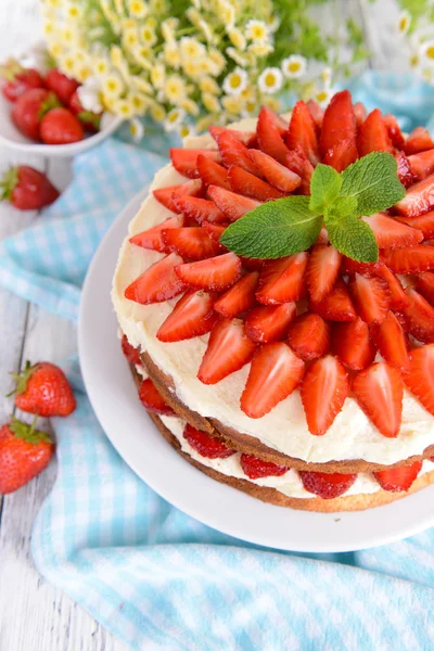 Delicious biscuit cake with strawberries on table close-up — Stock Photo, Image