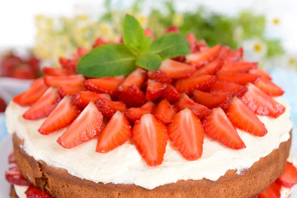 Heerlijke biscuit cake met aardbeien op tabel close-up — Stockfoto