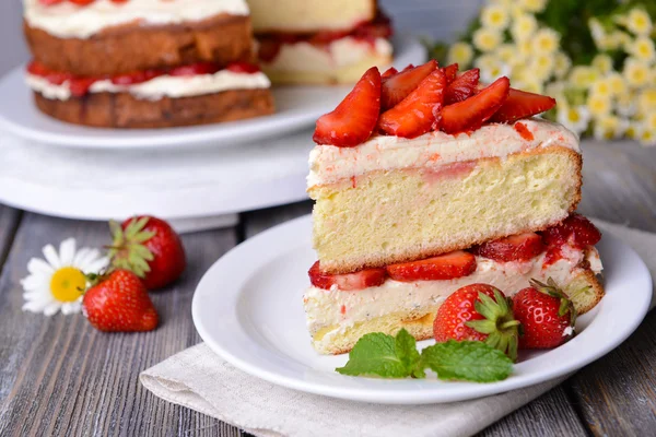 Heerlijke biscuit cake met aardbeien op tabel close-up — Stockfoto