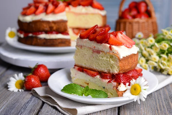Delicious biscuit cake with strawberries on table close-up — Stock Photo, Image