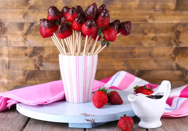 Strawberry in chocolate on skewers in cup on table close-up — Stock Photo, Image